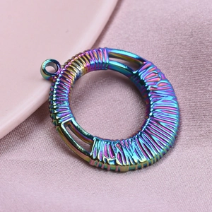 Macro shot of 304 stainless steel round pendant with rainbow finish and braided texture