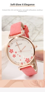 Close-up of women's rose gold watch featuring pink cherry blossom dial and leather strap