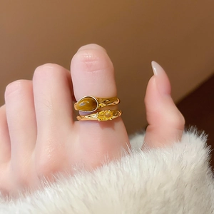 Close-up of double-layered gold lava rings with tiger eye and yellow gemstone accents