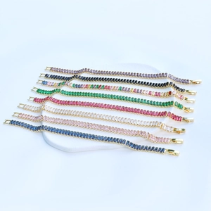 Close-up of rectangle-cut zircon tennis bracelets in multiple colors on stone display