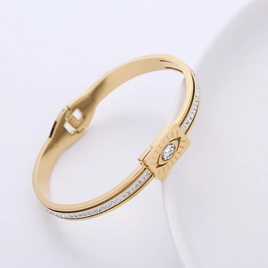 Macro view of gold Evil Eye bracelet featuring white zircon center and spring clasp detail