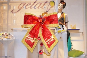 Large red and gold Christmas bow decoration with pine cones and festive greetings