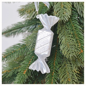 Dettaglio macro di un ornamento a caramella bianco perla con strisce argento sull'albero