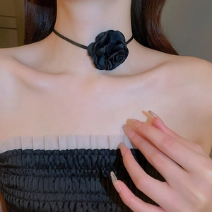 Close-up of black fabric flower choker necklace on a model showing French vintage style