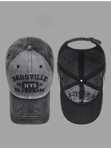 Close-up detail of vintage washed cotton baseball cap with embroidered lettering and adjustable strap