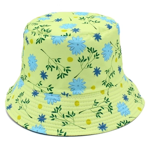 Detailed close-up of lime green reversible bucket hat with blue daisy floral patterns
