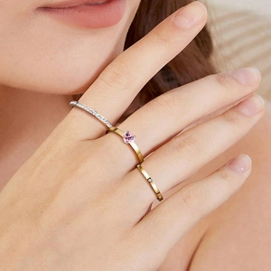 Detail shot of three stacked rings featuring a pink heart zircon and sparkling pavé bands