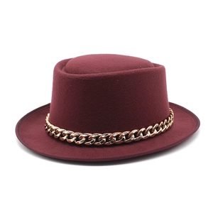 Detail of burgundy wool fedora hat featuring a chunky gold chain strap decoration