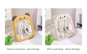 Detail view of cute bear-shaped foldable desktop makeup mirrors in pink and yellow colors