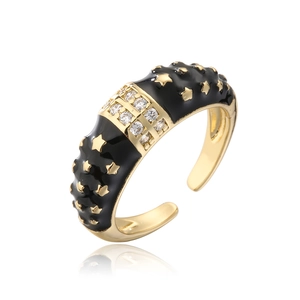 Detail of bohemian gold ring with black enamel, star motifs and sparkling zircon pavé