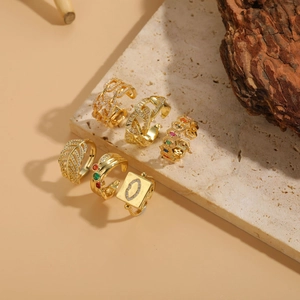 Detailed set of six gold-plated rings with leaf, chain, and heart motifs on a stone base