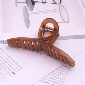 Detailed view of a brown transparent hair claw clip with a strong gold metal spring