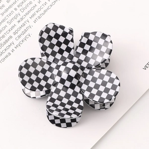 Macro shot of checkered flower hair claw clip with black and white acetate finish
