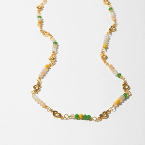 Close-up of golden heart links and colorful faceted beads on a bohemian necklace