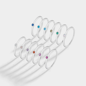 Vista detallada de doce anillos de plata con varias piedras de nacimiento de colores