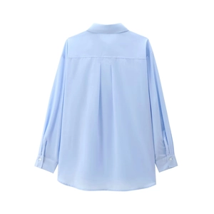 Détail du dos d'une chemise en coton bleu clair avec pli creux et texture nette