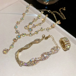 Detail of gold necklace, bracelet and ring set featuring colorful sparkling rhinestones