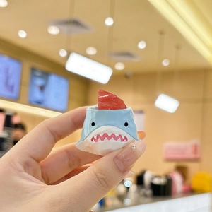 Blue shark ceramic dessert cup holding red jelly on a warm blurred cafe background