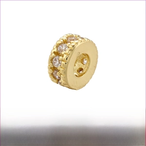 Détail macro d'une perle intercalaire en laiton doré avec des oxydes de zirconium pavés