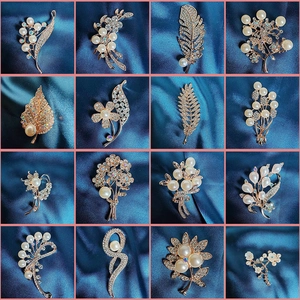 Elegant collection of camellia and floral brooches with pearls and crystals on silk