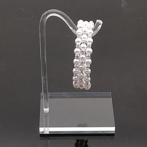 Three-layer faux pearl bracelet with silver rhinestone spacers on acrylic stand