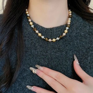 Vue rapprochée du bracelet vintage français en œil de tigre et perles sur le cou