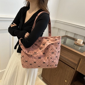Pink corduroy tote bag featuring black bow print and classic quilted pattern for women