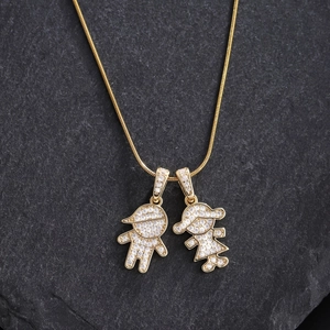 Detail of gold snake chain with boy and girl pendants encrusted with sparkling zircons