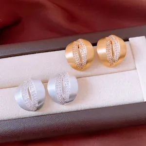 Minimalist C-shaped crisscross stud earrings with zircon inlay in gold and silver matte finish