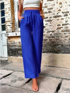 Détail du pantalon large taille haute bleu vif avec cordon élastique et boutons latéraux