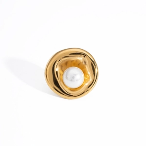 Macro detail of irregular gold metal earring featuring a white central pearl