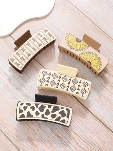 Detail of four matte rectangle hair claws with geometric, floral, and cow print patterns