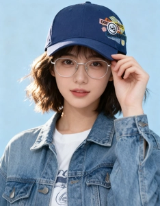 Detail of navy blue baseball cap featuring colorful smiley face embroidery and star patch