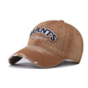 Detail of GIANTS embroidery on vintage washed brown denim baseball cap with distressed finish