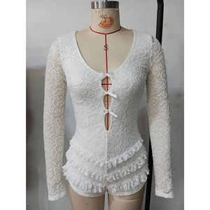 Détail d'un combishort en dentelle blanche avec nœuds satinés et ourlet à volants