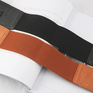 Detail of crocodile pattern leather and elastic waist belts in black and brown