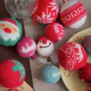 Flat lay of handmade red and white Christmas wool felt balls and snowman ornaments