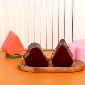Detailweergave van hartvormige siliconenvormen en afgewerkte bruine chocolade harten op dienblad