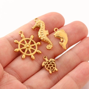 Detailed view of gold marine pendants including seahorse, fish, helm, and turtle charms