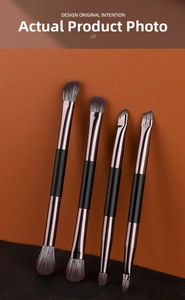 Detail of 4-piece double-ended makeup brush set with matte black handles and bronze tubes