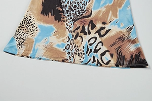 Détail de l'ourlet de robe avec imprimé léopard abstrait et finitions à double surpiqûre