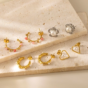 Elegant gold and silver faux pearl earrings set on decorative stone slabs for women