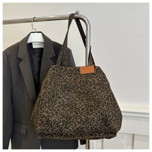 Detailed view of leopard print tote bag with orange leather patch and front pocket rivets