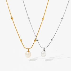 Macro detail of gold and silver pearl pendant necklaces with elegant snake bone chains