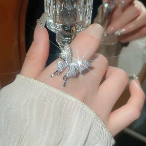 Detail of silver butterfly ring with shimmering crystals on model's finger