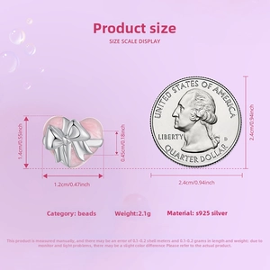 Detail view of pink heart gift box bead in 925 silver with a bow next to a US quarter coin