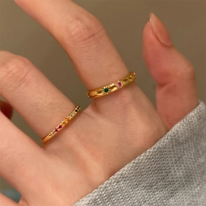 Dettaglio degli anelli placcati in oro 18 carati con zirconi colorati in stile minimalista