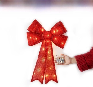Detail of red glitter LED Christmas bow with warm lights and battery pack