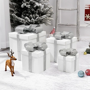 Christmas gift box set with white boxes and silver bows in a snowy holiday display scene