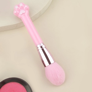 Gros plan du pinceau poudre patte de chat rose avec poils doux et virole or rose
